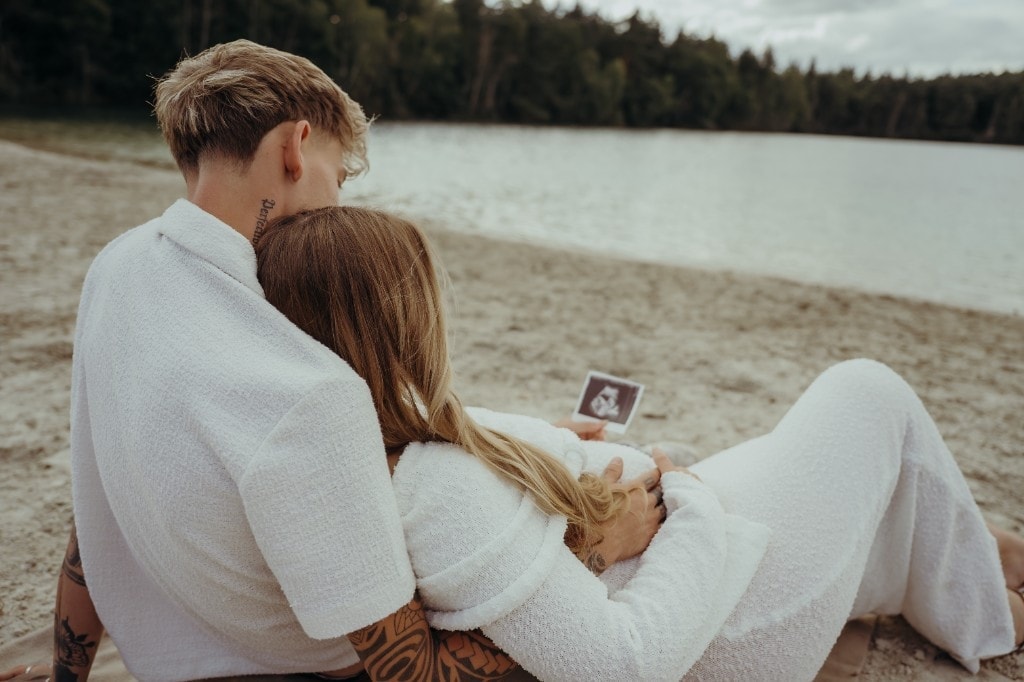 Paar sitzt am Strand mit Ultraschallbild