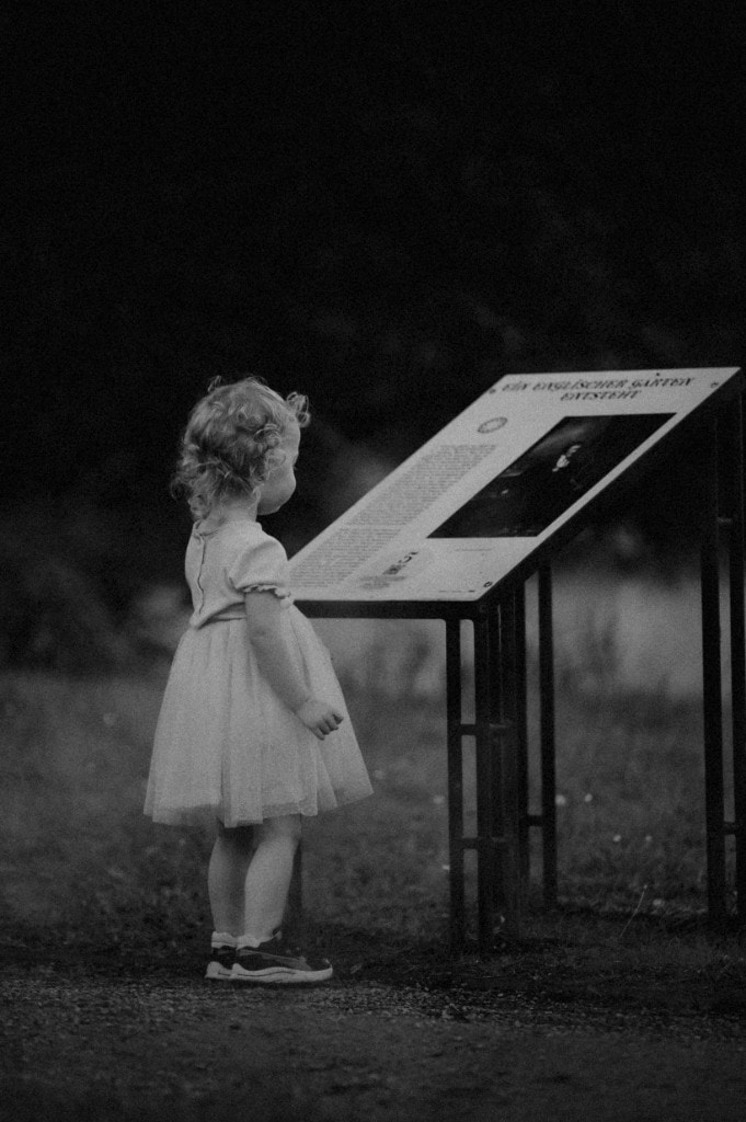 Kind betrachtet Infotafel im Park