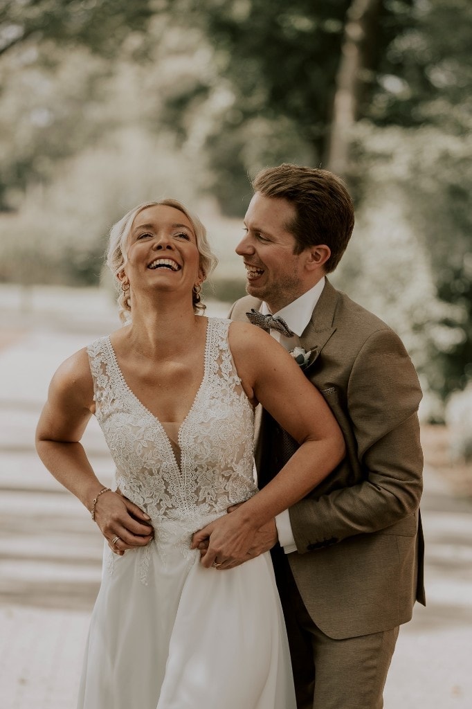 Lachendes Brautpaar bei einem natürlichen Hochzeitsportrait