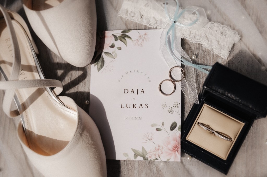 Hochzeitseinladung und Brautaccessoires im Flat-Lay — Schuhe, Ringe und Strumpfband