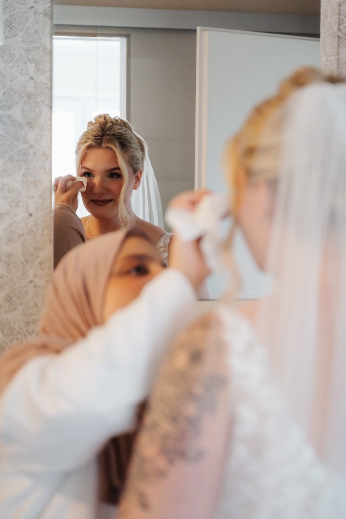 Getting Ready — Braut im Spiegel mit zärtlichem Moment vor der Trauung